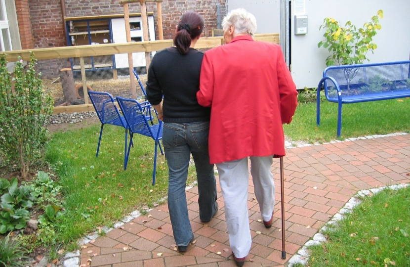 A resident of a care home with a carer.