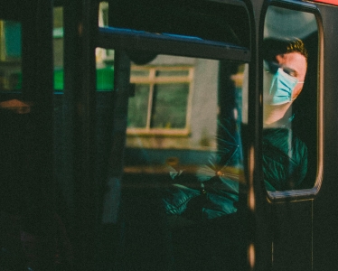 A generic image of a perosn wearing a face mask on public transport.